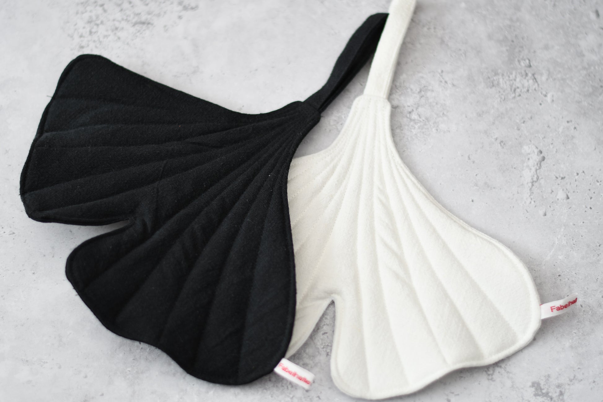 Ein Set aus zwei handgenähten Topflappen in der markanten Form eines Ginkgoblattes aus  Leinen.