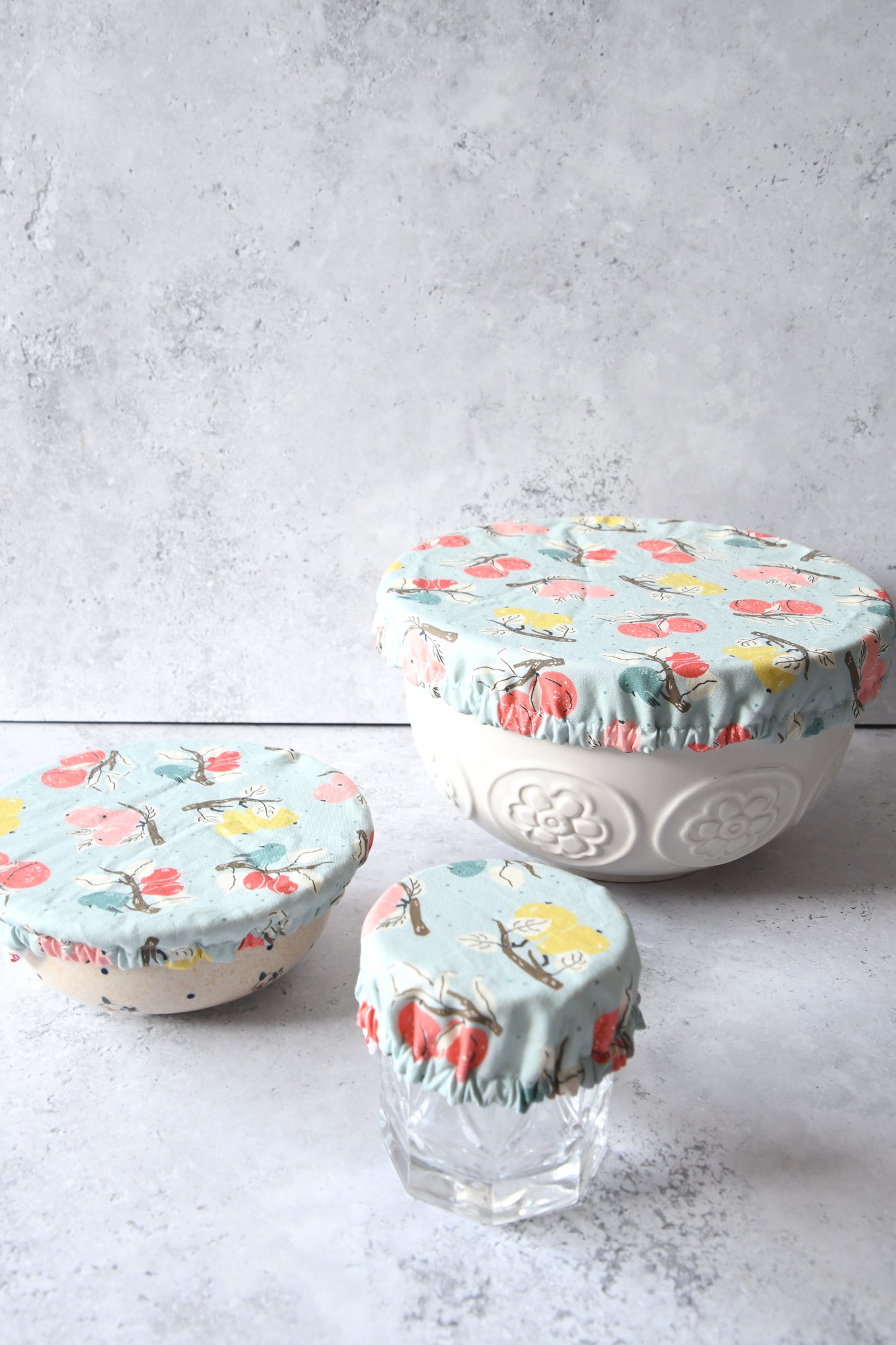 Dreier-Set wiederverwendbarer Schüsselhauben in den Größen S, M und L mit hellblauem Obstzweige-Muster.