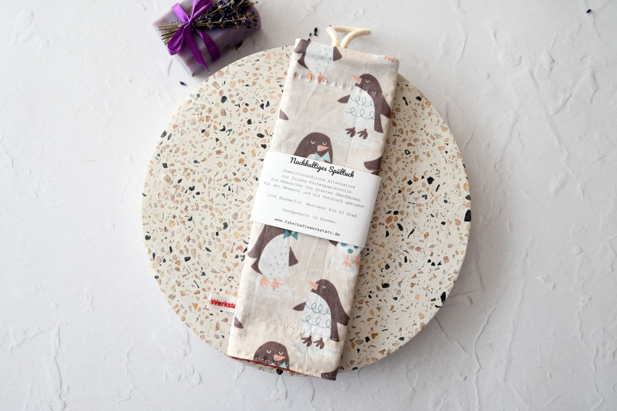 Nachhaltiges, handgenähtes Spültuch mit niedlichen Pinguin-Motiven auf beigem Hintergrund von Fabelhaftewerkstatt.
